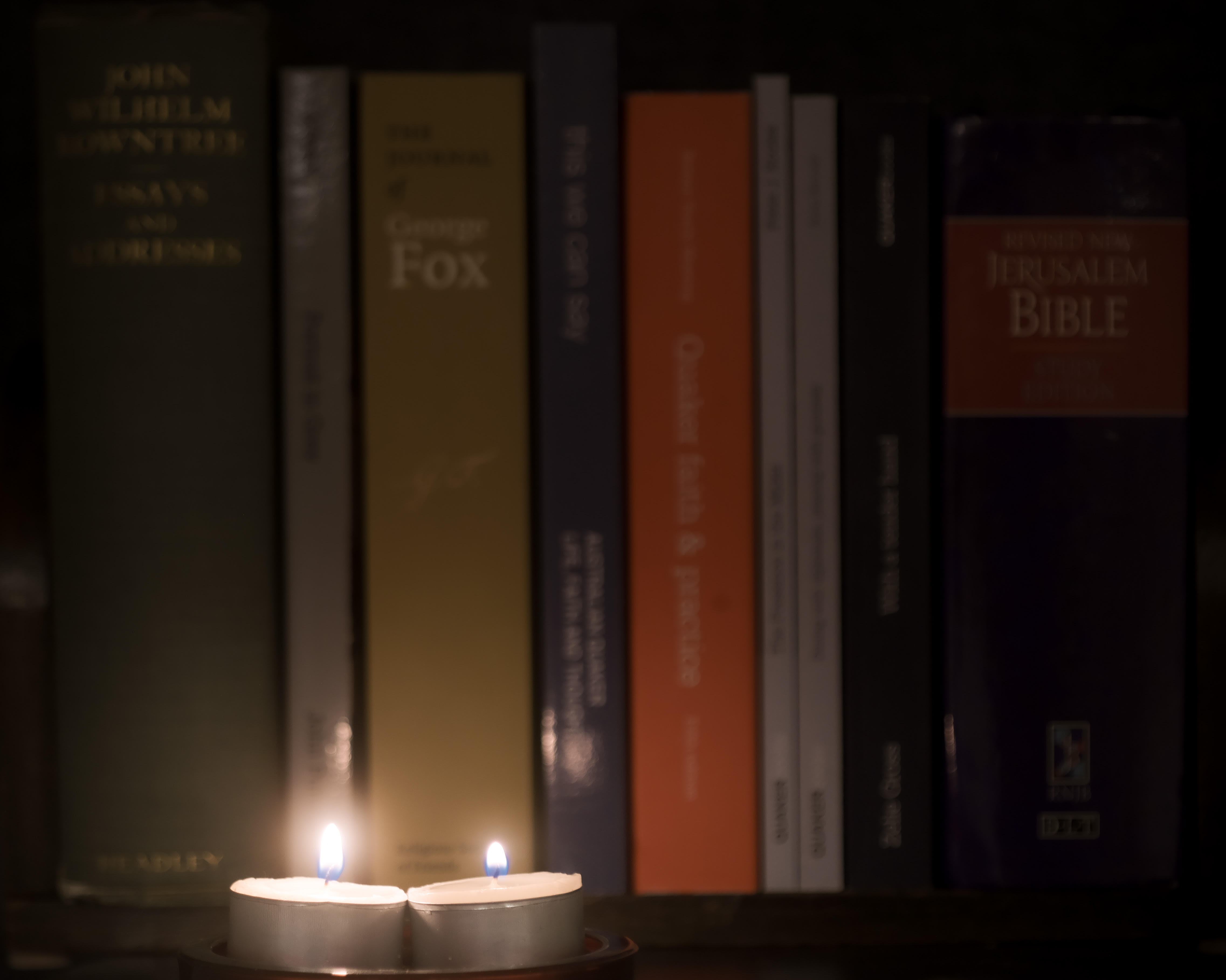 two small candles in front of books